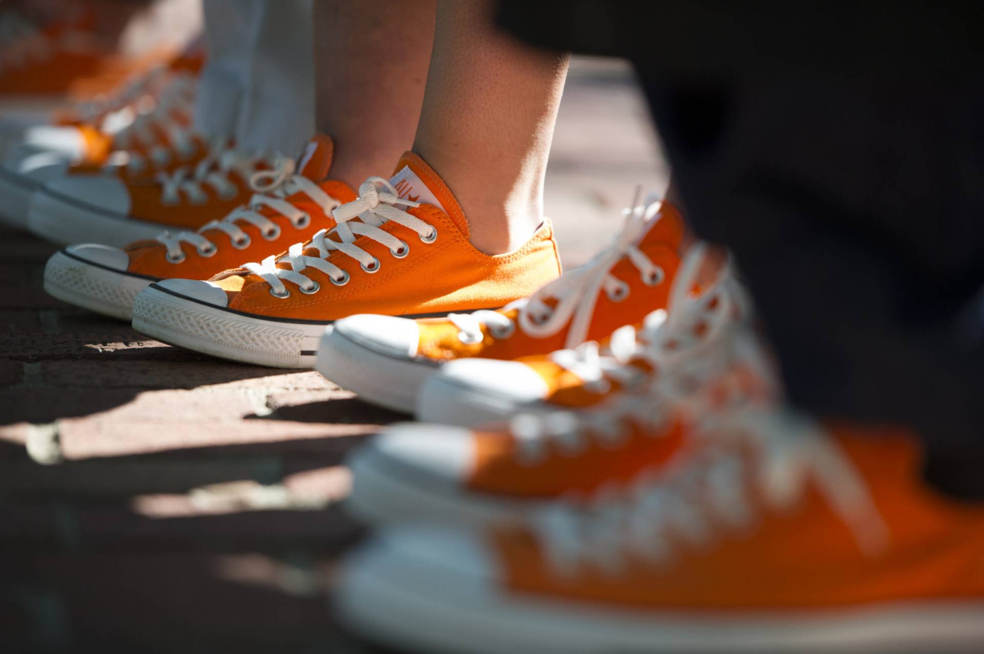 students feet in orange tennis shoes